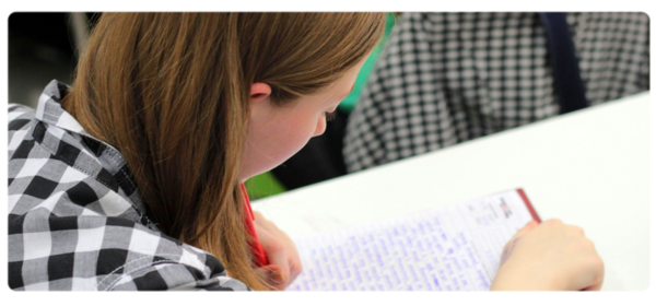 A social work student writes on a pad of paper